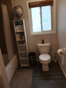 a small bathroom with a toilet and a window at Comfortable room B in Kitchener