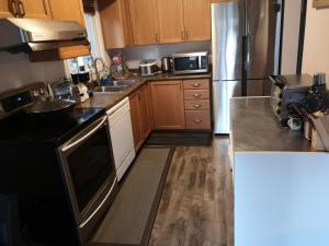 a kitchen with wooden cabinets and a stainless steel refrigerator at Comfortable room B in Kitchener