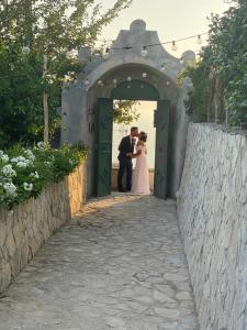 Una novia y un novio parados en una puerta en Villa Donna Antonia - Amalfi Coast en Conca dei Marini