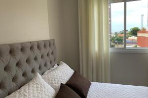 a bedroom with a bed with a window at Suite Completa Master Collection in Passo Fundo