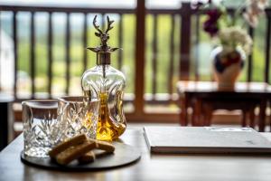 a bottle of oil and glasses on a table at Inverskilavulin Estate Lodges in Fort William