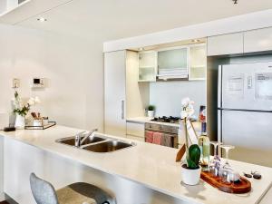 布里斯班Amazing River View - 3 Bedroom Apartment - Brisbane CBD - Netflix - Fast Wifi - Carpark的带白色橱柜和水槽的厨房