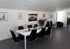 una sala de conferencias con una mesa blanca y sillas negras en STF Kalix Vandrarhem, en Kalix