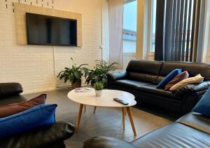 a living room with couches and a table and a tv at STF Kalix Vandrarhem in Kalix