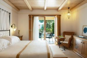 a bedroom with a large bed and a patio at Mitsis Selection Blue Domes in Kardamaina