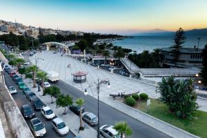 Una ciudad con coches estacionados en una calle y el océano en B&B Centrale Affittacamere, en Reggio Calabria