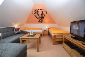 ein Wohnzimmer mit einem Sofa und einem TV in der Unterkunft Haus Celina 1 Zimmer Appartement in Büsum