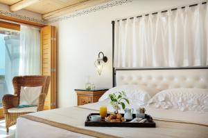 a bedroom with a bed with a tray of food on it at Mitsis Selection Blue Domes in Kardamaina