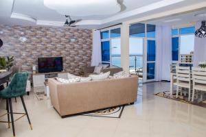 a living room with a couch and a table and a television at EMIRATES REEF APARTMENT 8D in Mombasa