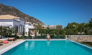 a woman sitting in the pool of a villa at Mitsis Selection Blue Domes in Kardamaina