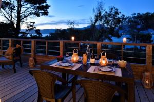 a wooden deck with a table with lights on it at Résidence & Hotel U Livanti ECOLABEL in Propriano