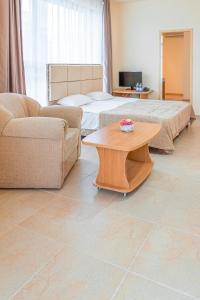 a living room with two beds and a coffee table at Hotel Avenue in Sunny Beach