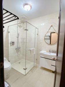 a bathroom with a shower and a toilet and a sink at Little B&B in Taitung City