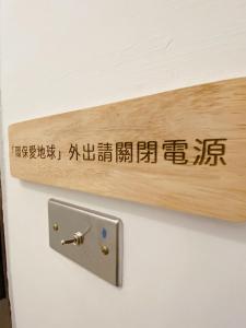 a wooden sign on a wall with writing on it at Little B&B in Taitung City