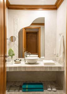 a bathroom with a sink and a large mirror at Mitsis Selection Blue Domes in Kardamaina