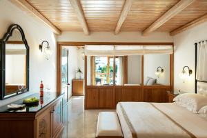 a bedroom with a large bed and a mirror at Mitsis Selection Blue Domes in Kardamaina