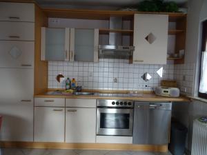 een keuken met witte kasten en een roestvrijstalen oven bij Ferienwohnung Rosemarie in Kamp-Bornhofen