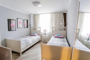 duas camas num pequeno quarto com flores cor-de-rosa em Smile Hostel em Níjni Novgorod