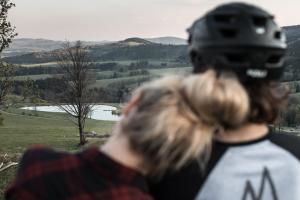 een persoon kijkt uit een raam naar een meer bij Penzion Kolovna in Hynčice pod Sušinou