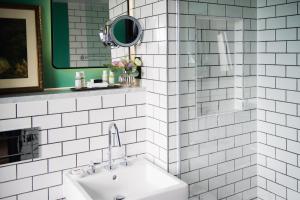 a white tiled bathroom with a sink and a mirror at Avon Gorge by Hotel du Vin in Bristol