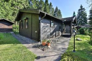 una pequeña casa verde con una acera delante de ella en Waldsee-Ferienhaus-mit-Kamin-W-Lan, en Clausthal-Zellerfeld