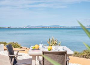 een tafel en stoelen met uitzicht op de oceaan bij Hotel Lago Dorado - Formentera Break in La Savina