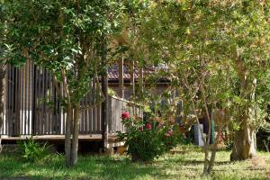 a wooden deck in a yard with trees and flowers at Résidence & Hotel U Livanti ECOLABEL in Propriano