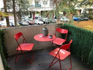 una mesa roja y 4 sillas en un patio en LA FORCLAZ - Centre ville & Lac, Balcon, Parking, en Annecy