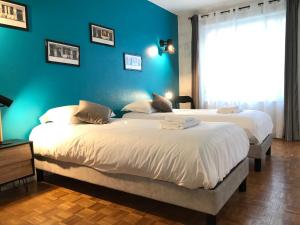 2 camas en un dormitorio con una pared azul en LA FORCLAZ - Centre ville & Lac, Balcon, Parking, en Annecy