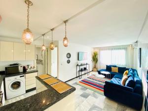 AiM HOUSE في مراكش: مطبخ وغرفة معيشة مع أريكة زرقاء
