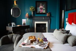 ein Tablett mit Essen auf einem Bett in einem Zimmer mit einem Kamin in der Unterkunft Avon Gorge by Hotel du Vin in Bristol