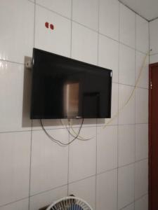 TV de pantalla plana colgada en la pared en Pousada Conceição, en Florianópolis