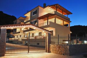 a large house with a fence in front of it at Achladi Beach in Achladi