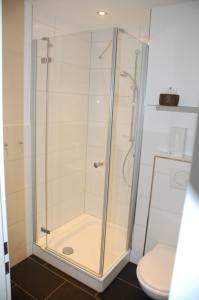 La salle de bains est pourvue d'une douche en verre et de toilettes. dans l'établissement Hotel Alte Schule, à Bad Berleburg