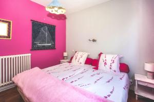 une chambre rose avec un lit aux murs roses dans l'établissement Hon-ty, à Groix