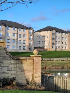 a retaining wall in front of some apartment buildings at Pond view in Airdrie