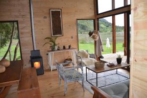 a living room with a table and chairs and a fireplace at Cabañas Almalik in Ralún