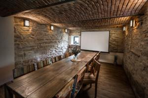 een grote houten tafel in een kamer met een wit scherm bij Penzion Kolovna in Hynčice pod Sušinou