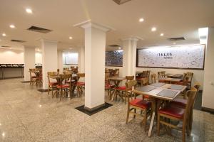 a restaurant with tables and chairs in a room at Samba Belo Horizonte Centro in Belo Horizonte