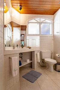 La salle de bains est pourvue de toilettes, d'un lavabo et d'un miroir. dans l'établissement Atlantica Jungle Lodge, à Abraão