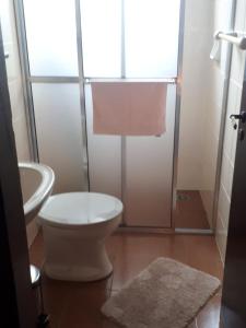 a bathroom with a white toilet and a sink at Villa Chalé dos Alpes in Monte Verde