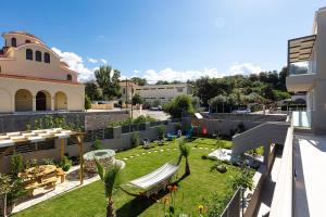 a balcony with a yard with chairs and a garden at Lagoon Seabreeze Villa, Sumptuous Retreat, By ThinkVilla in Panormos Rethymno