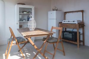 a kitchen with a table and two chairs and a refrigerator at Casa Artemisia in Filicudi