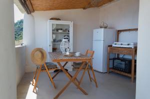 a kitchen with a wooden table and a refrigerator at Casa Artemisia in Filicudi