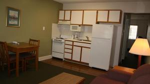 a kitchen with a white refrigerator and a table at Affordable Suites Shelby in Shelby
