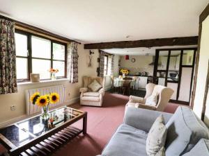 a living room with a couch and a table at Cwm Chwefru Holiday Cottages in Llanafan-fawr