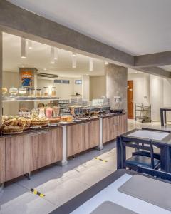 a large kitchen with a bunch of food on display at Happy Hotel Pajuçara in Maceió