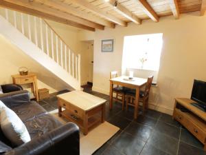 a living room with a couch and a table at Menai Cottage in Llanfairpwllgwyngyll