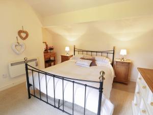 a bedroom with a large bed and two lamps at Menai Cottage in Llanfairpwllgwyngyll