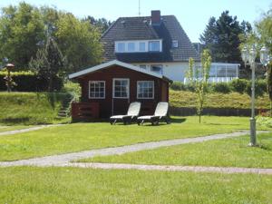 two chairs in a yard in front of a house at Bungalow-Lerchennest in Wittdün